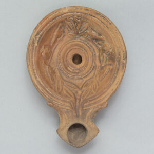 Circular terracotta lamp with birds carved into its surface.