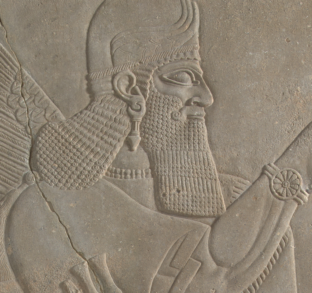 Close up of a relief carving of a man with long hair and a long beard, wearing a helmet.