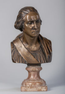 Bronze-colored bust of George Washington draped in a toga, with a marble pedestal.