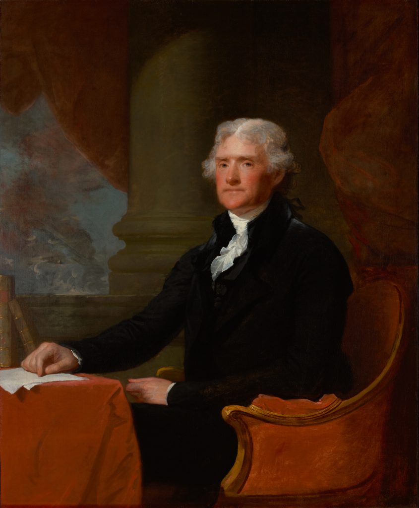 Portrait of a white-haired man wearing a black suit and sitting upright in a red armchair in front of a column.