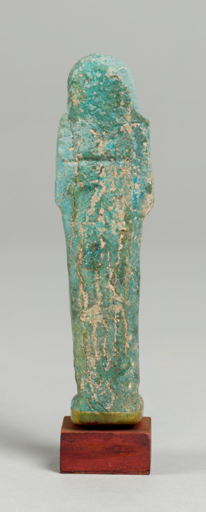 Alternate view of A green tinted ancient Egyptian figurine carved into the shape of a mummy.