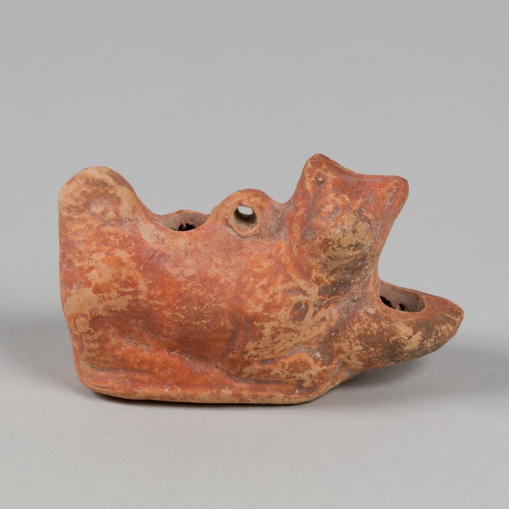 Red terracotta lamp shaped like a dog's head.