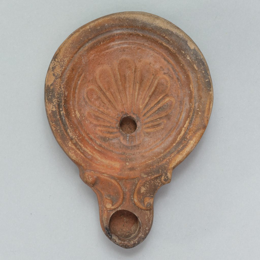 Red terracotta, pear-shaped piece with a scallop shell carved in the center.