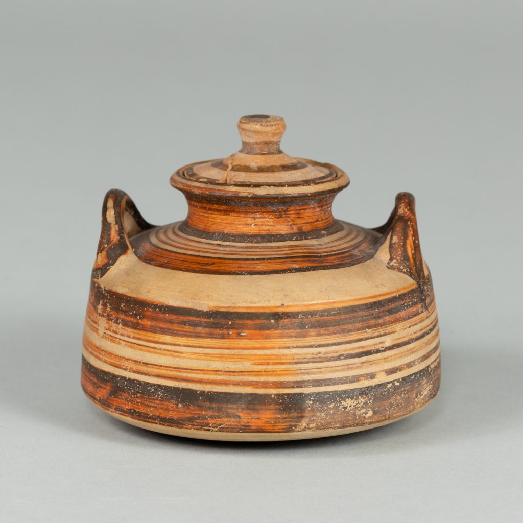 Low vessel with lid and two handles, painted with red and black stripes of varying widths.