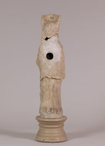 Alternate view of Terracotta statue of a goddess wearing a tall headdress and carrying a fawn, mounted on a circular stand.