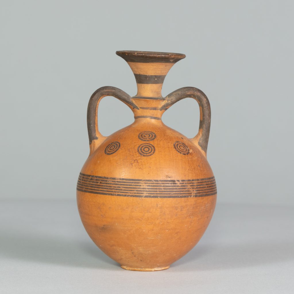 Orange flask with two handles, painted with black stripes and circles.