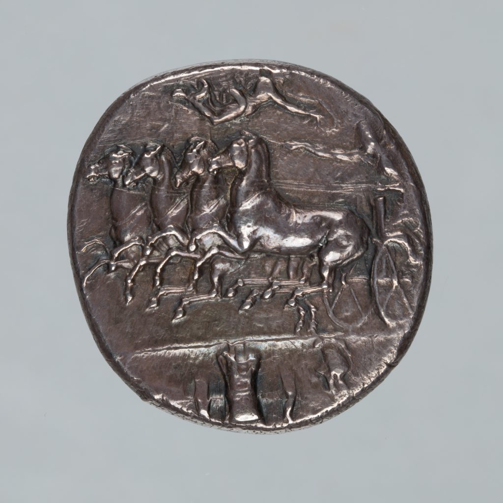 Alternate view of Ancient silver coin featuring the profile of a woman and two small fish.