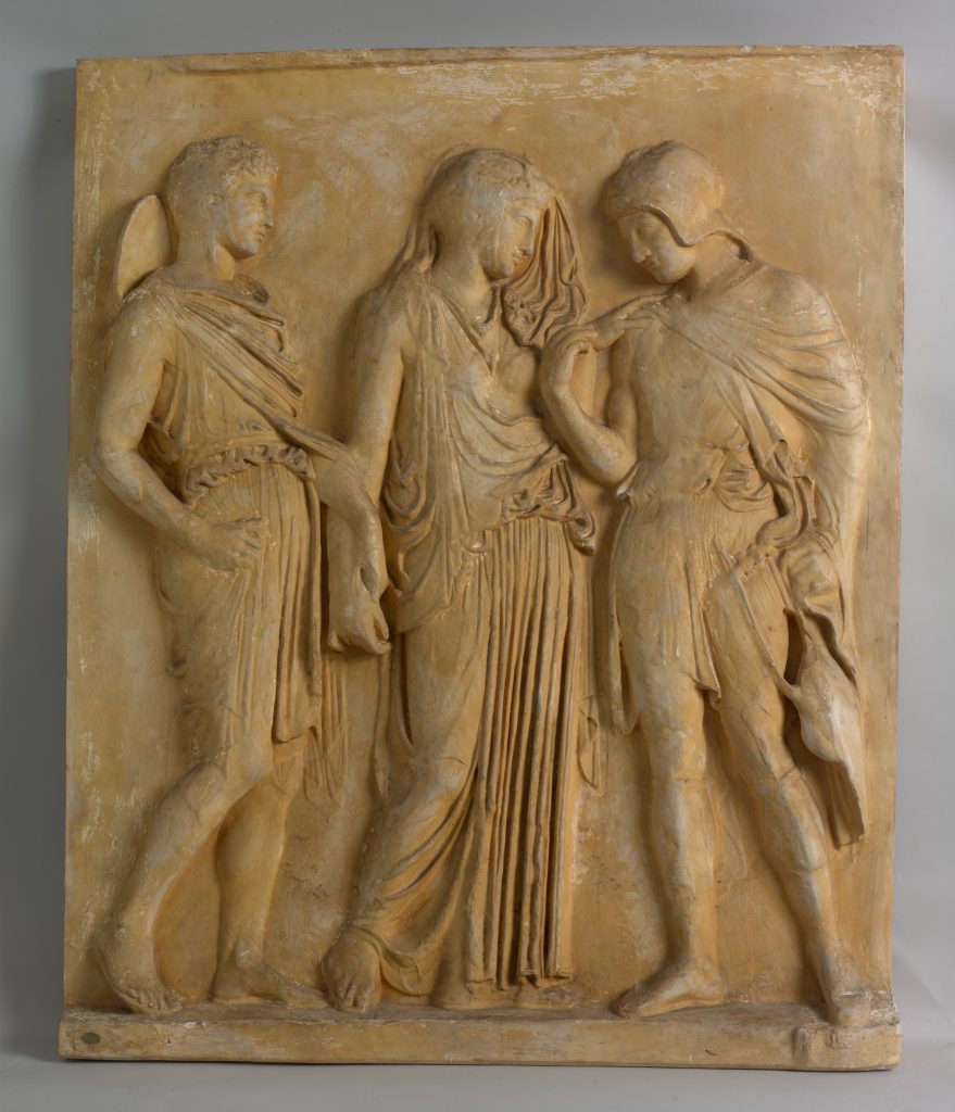 Plaster relief with three male figures dressed in togas.
