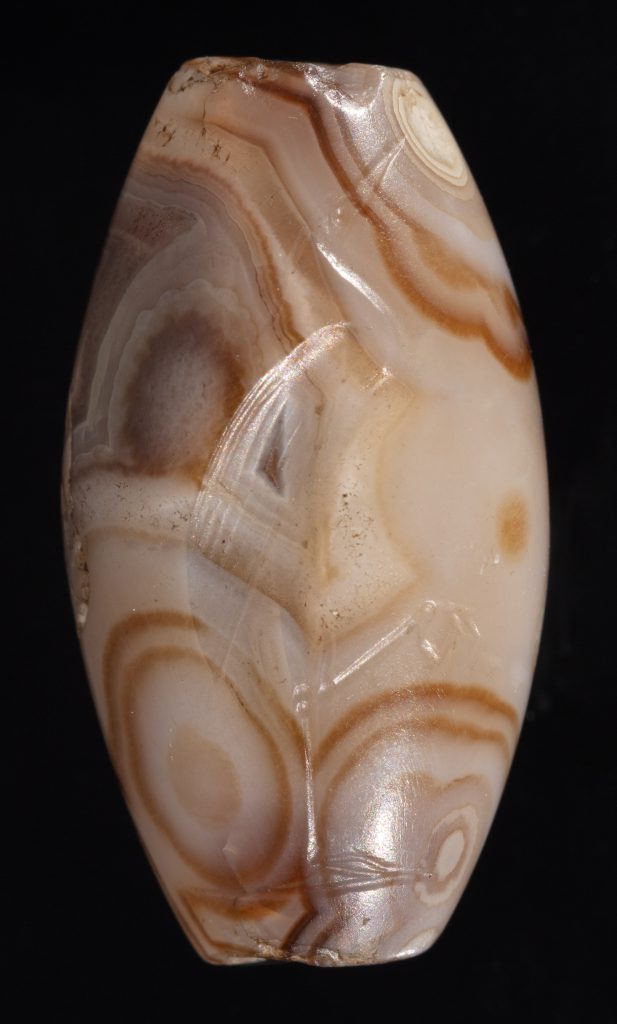 Ovular agate bead with striated pattern in shades of amber, taupe, and cream.