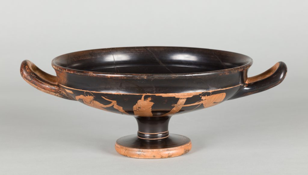 Low, black terracotta cup with two handles and red-figure painting depicting a mythological scene.