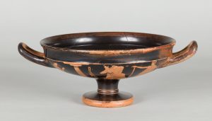 Alternate view of Low, black terracotta cup with two handles and red-figure painting depicting a mythological scene.