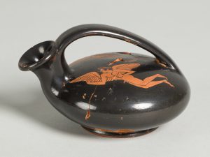 Disc-like terracotta oil flask with a top handle and red-figure painting of a winged figure.