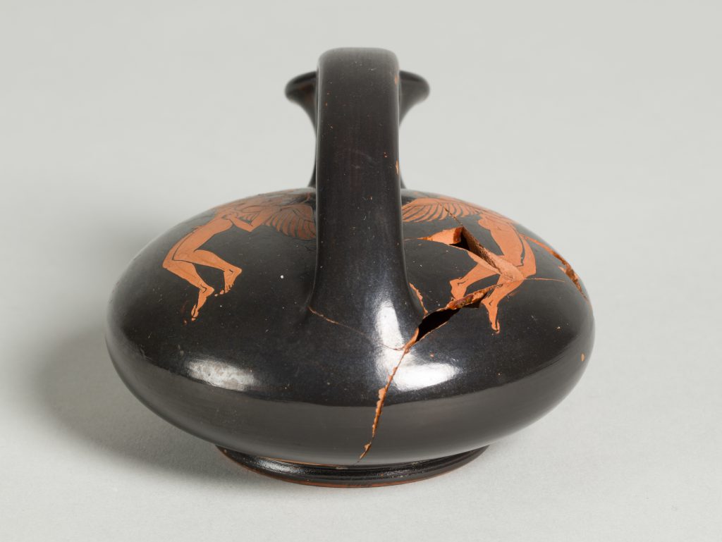 Alternate view of Disc-like terracotta oil flask with a top handle and red-figure painting of a winged figure.