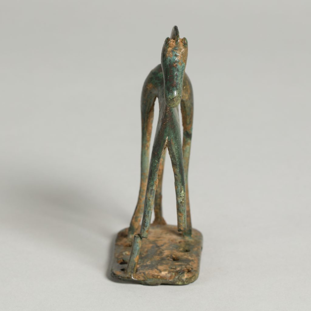 Alternate view of Bronze figurine of a horse mounted on a small base, its back leg broken in one spot.