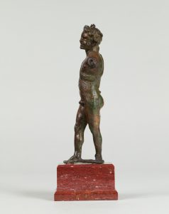 Alternate view of Small bronze statue of a dancing satyr with one arm extended and the other arm missing. Mounted on a wooden base.