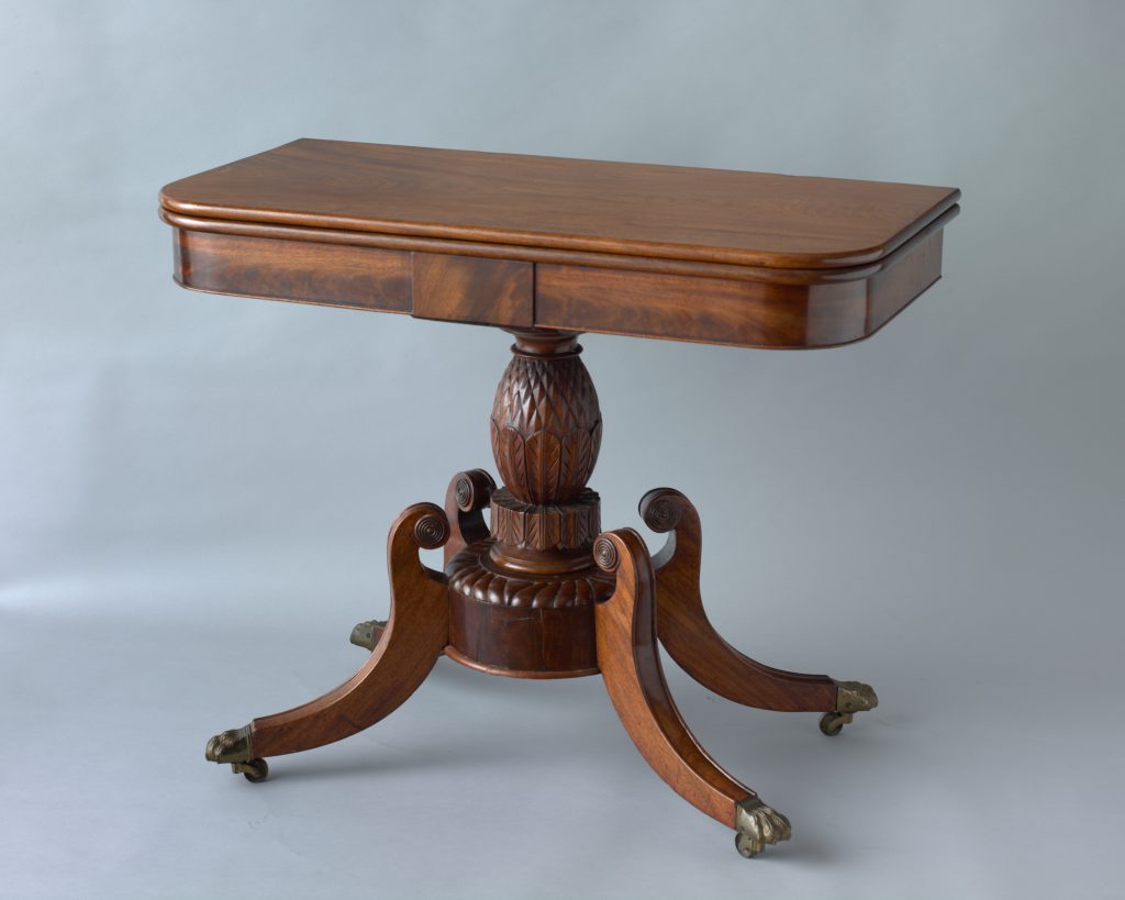 Mahogany card table with an ornatiely carved base.