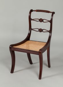 Dark mahogany chair with a woven cane seat.