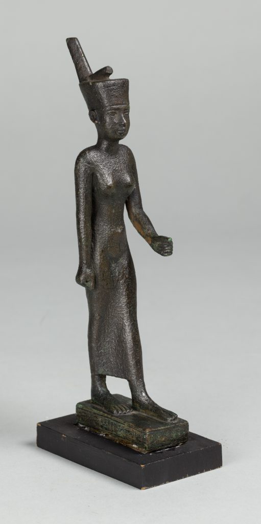 Black Egyptian stauette wearing a headdress, standing on a small platform.