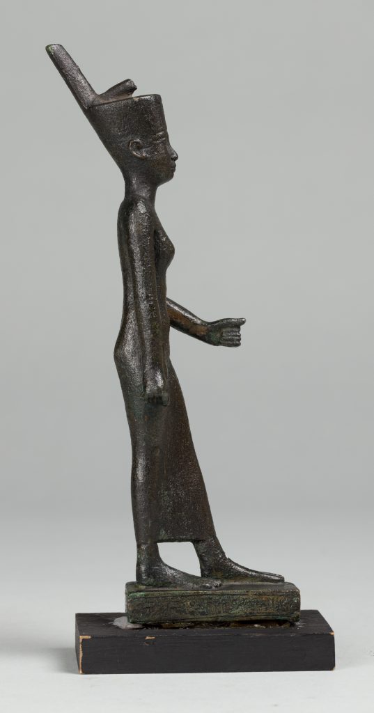 Alternate view of Black Egyptian stauette wearing a headdress, standing on a small platform.
