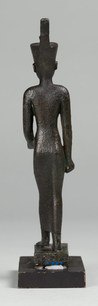 Alternate view of Black Egyptian stauette wearing a headdress, standing on a small platform.