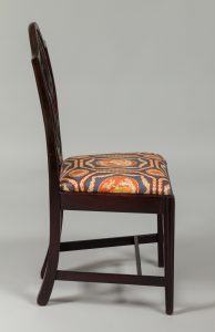Alternate view of Dark mahogany chair with seat upholstered in blue, orange, and gold patterned fabric.