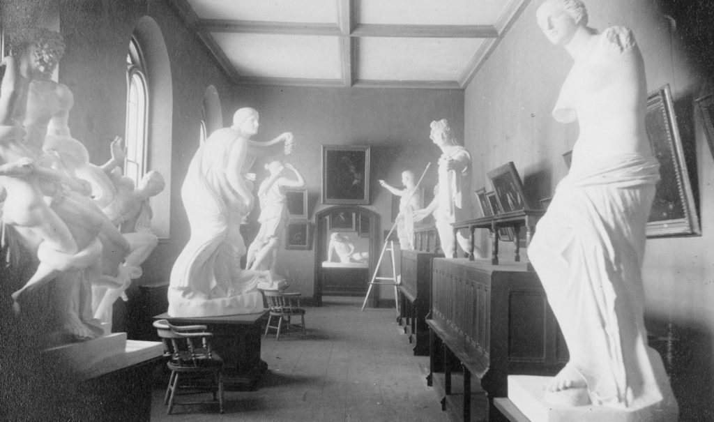 Long haul with several plaster cast statues lining the walls, as well as framed artworks.